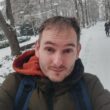 Marek Stejskal venku v zimě, oblečený do teplé bundy a s batohem.