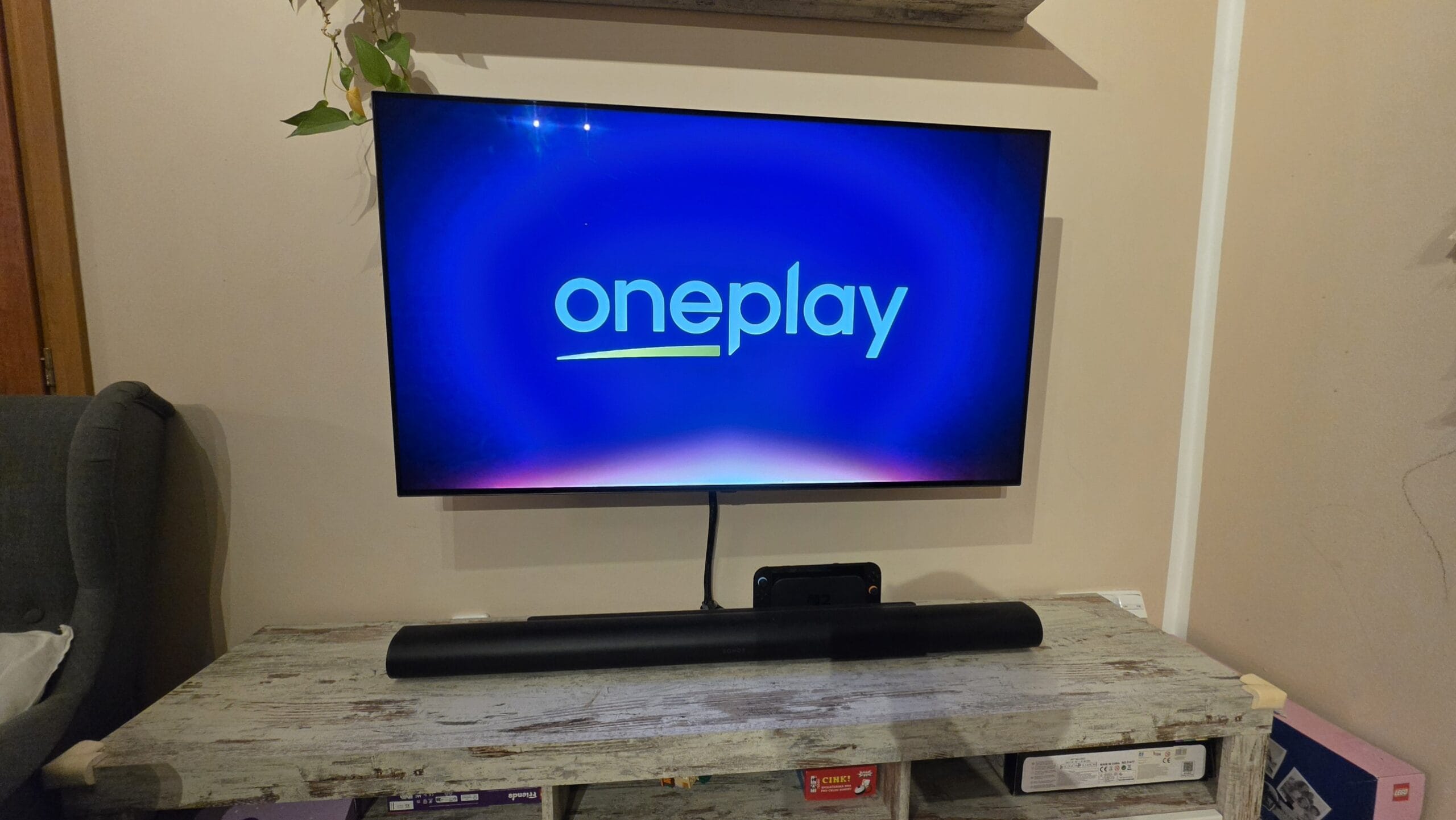 Televize s logem Oneplay, zobrazená na konferenčním stolku.
