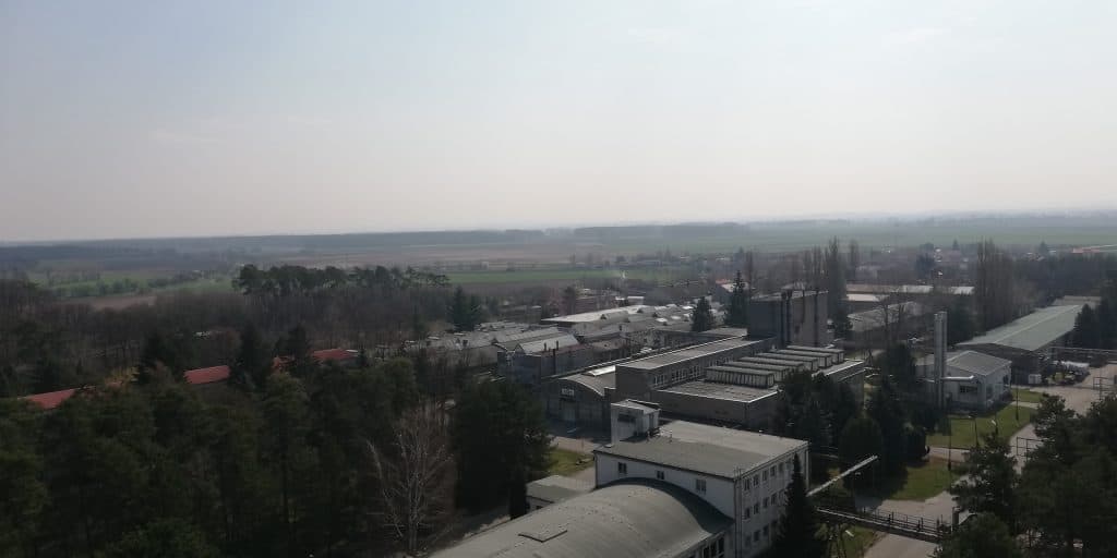 Pohled na průmyslovou zónu s továrnami a zelení v okolí.