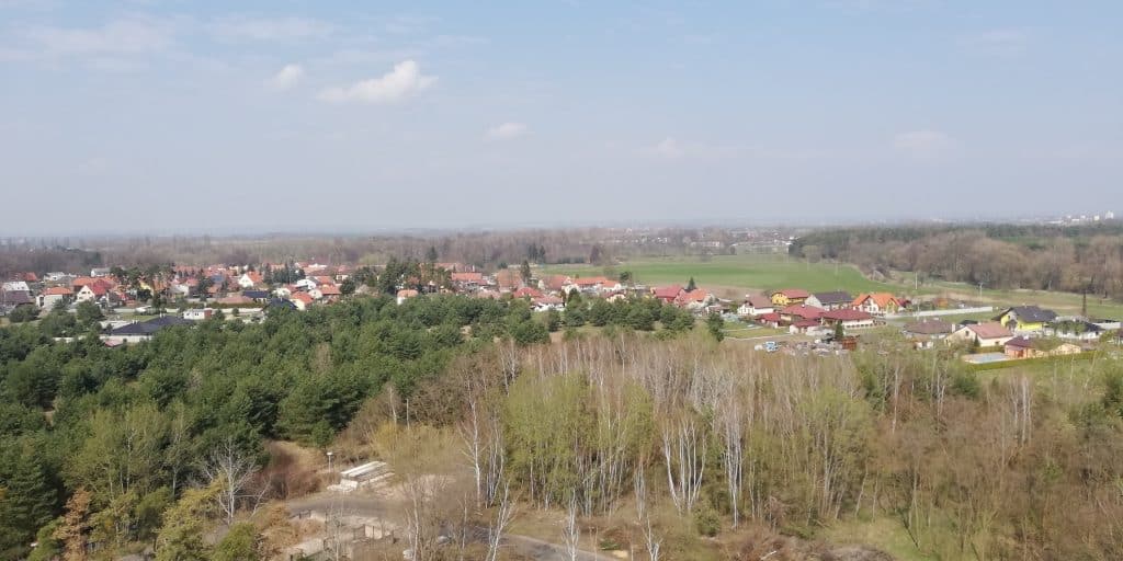 Panoramatický výhled na Zvěřínek s vesnicí a okolní přírodou.