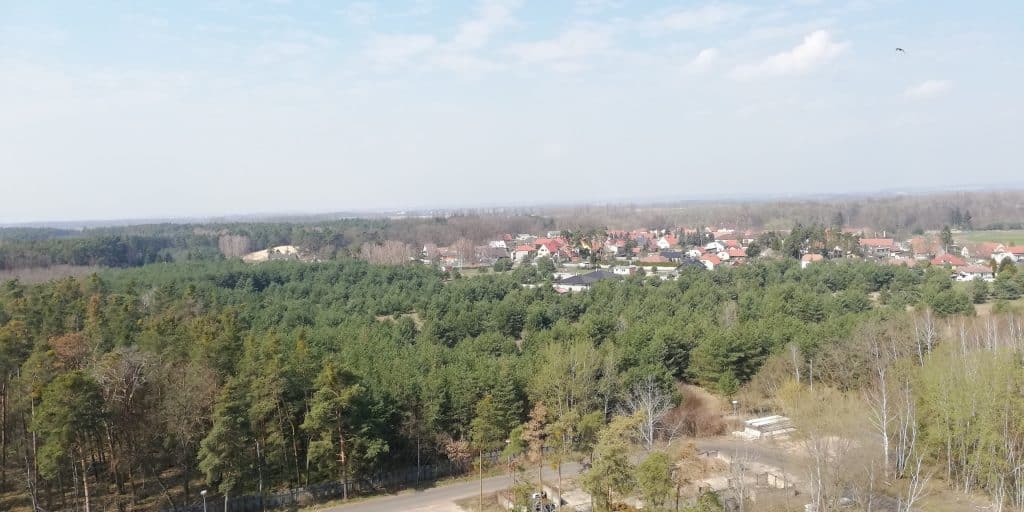 Pohled na Zvěřínek a okolní lesy s vesnicí v pozadí.