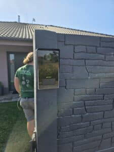 Kamerový systém na zdi s videokamerou a dveřním zvonkem.