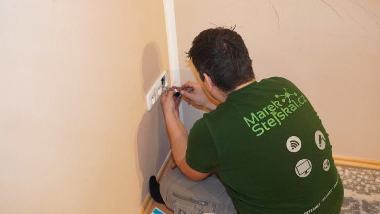 Technik zapojuje zásuvku pod místem instalace televize
