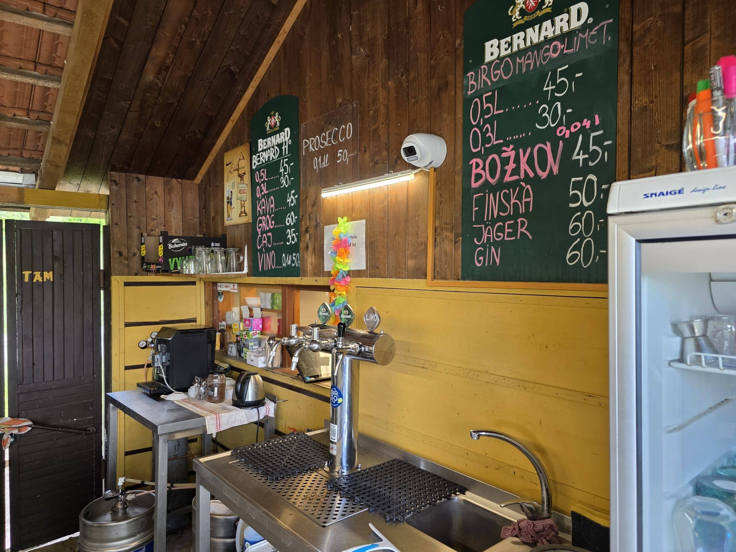 Uvítací bar s nabídkou alkoholických nápojů a menu na tabuli.
